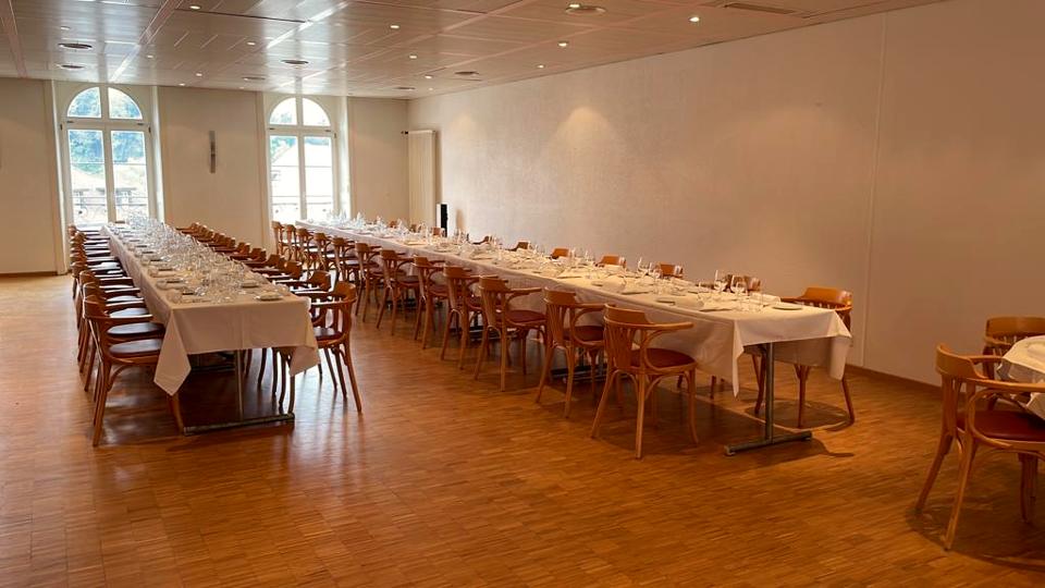 La grande salle dressée en longues tables de banquet
